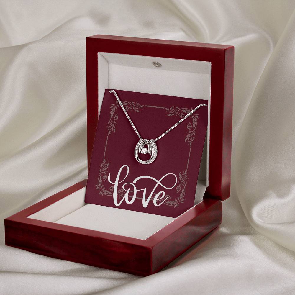 Mahogany jewelry box in front of silk background displaying Lucky in Love.
