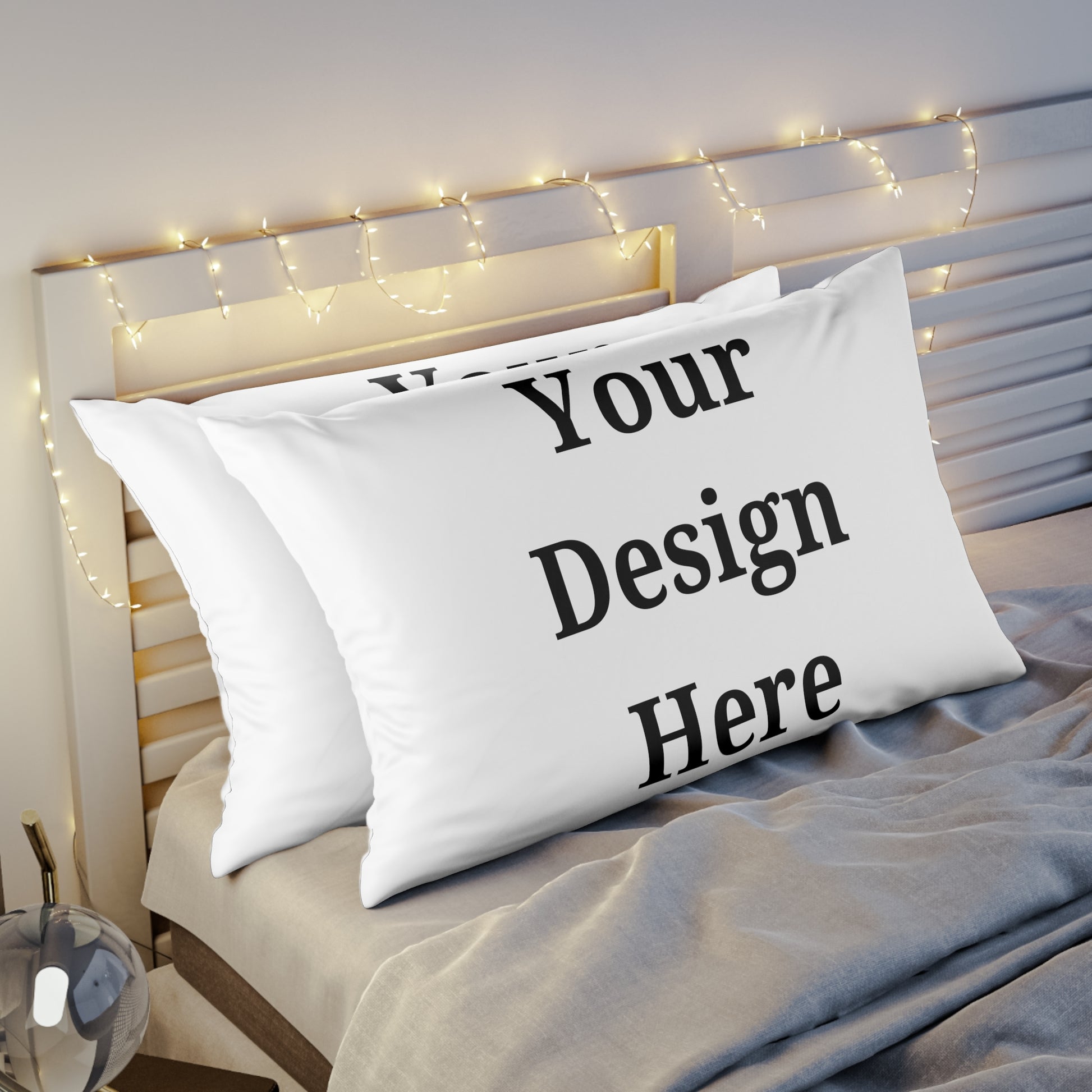 Two pillow cases on bed featuring “your design here”.