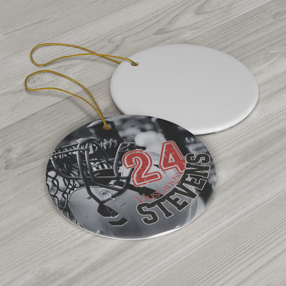 Ceramic ornament featuring photo of football helmet with personalized example of player name Stevens and player number 24 laying on countertop.