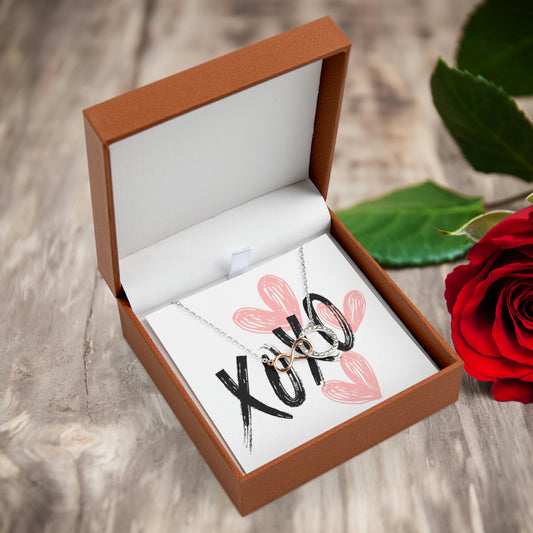 Infinity Circle Pendant necklace hanging infringe of XOXO message card with pink hearts in Leather jewelry box.