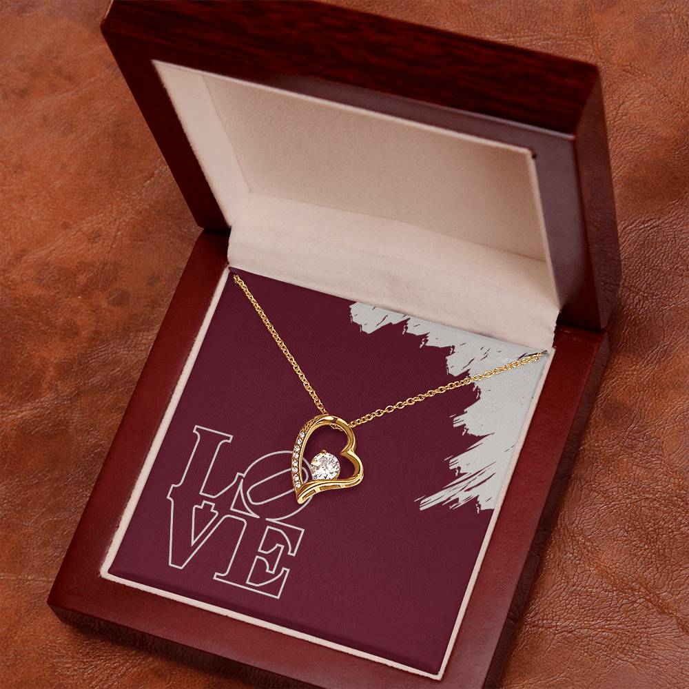 Polished gold heart pendant necklace featuring LOVE message card in mahogany jewelry box.