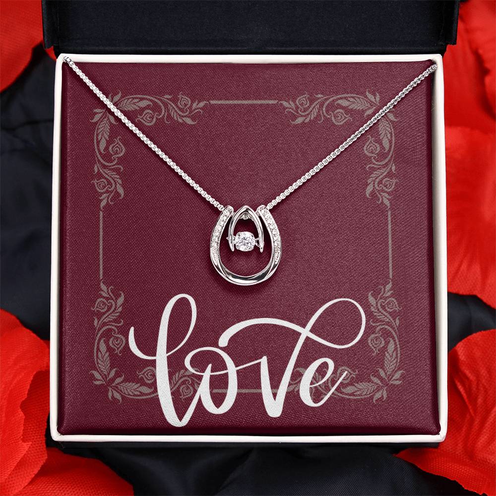 Lucky in Love white gold necklace displayed in front of message card reading LOVE inside standard black box.