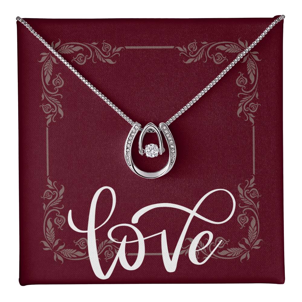 Lucky in Love Horseshoe pendant necklace hanging in front of message card that reads LOVE