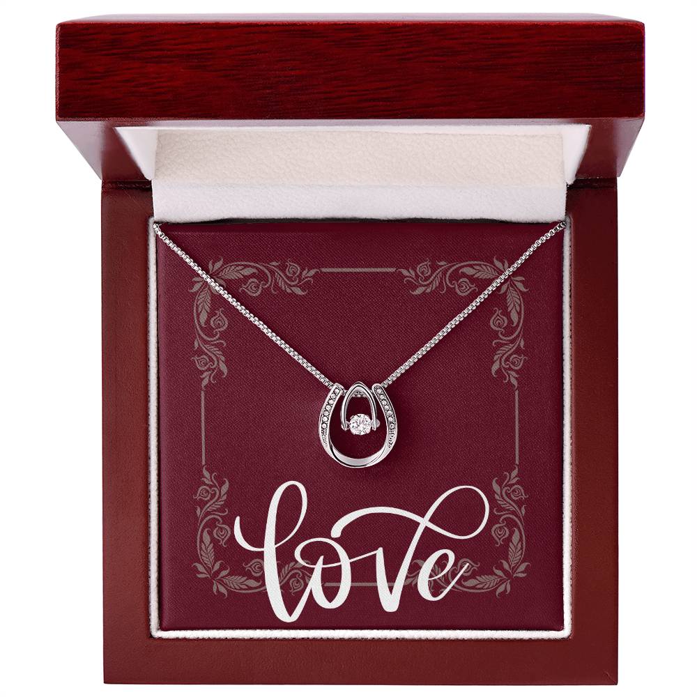 Mahogany box with white gold Lucky in Love necklace displayed inside.