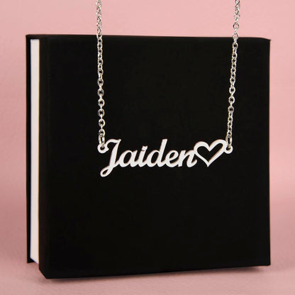 The name Jaiden in the silver personalized name necklace in front of standard black jewelry box.