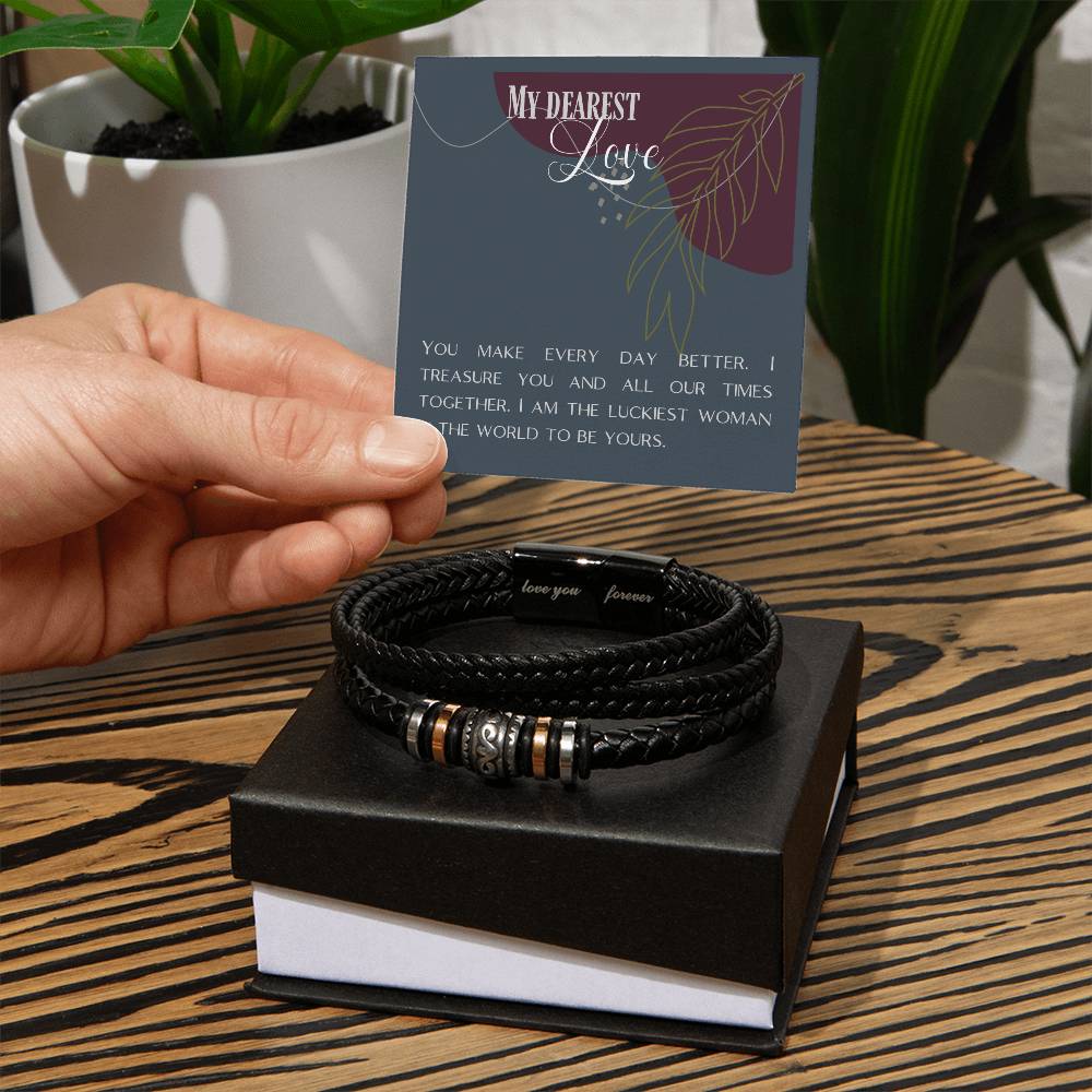 Hand holding message card over Love Knot bracelet sitting on wooden table.