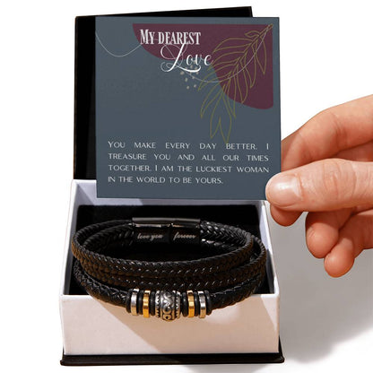 Hand holding message card over Love Knot bracelet in front of standard black box.