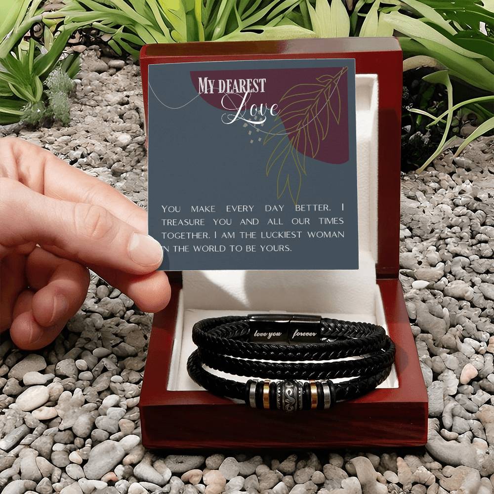 Hand holding message card over Love Knot bracelet in front of mahogany jewelry box.