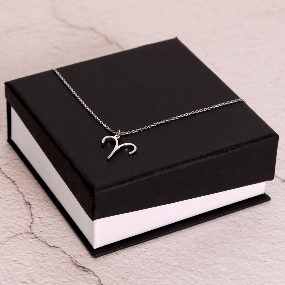 Stainless Steel Zodiac charm necklace laying on elegant black box.