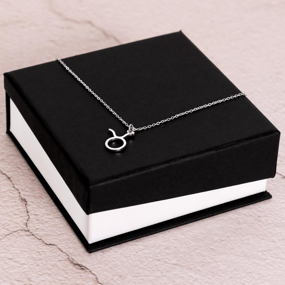 Stainless Steel Zodiac charm necklace laying on elegant black box.