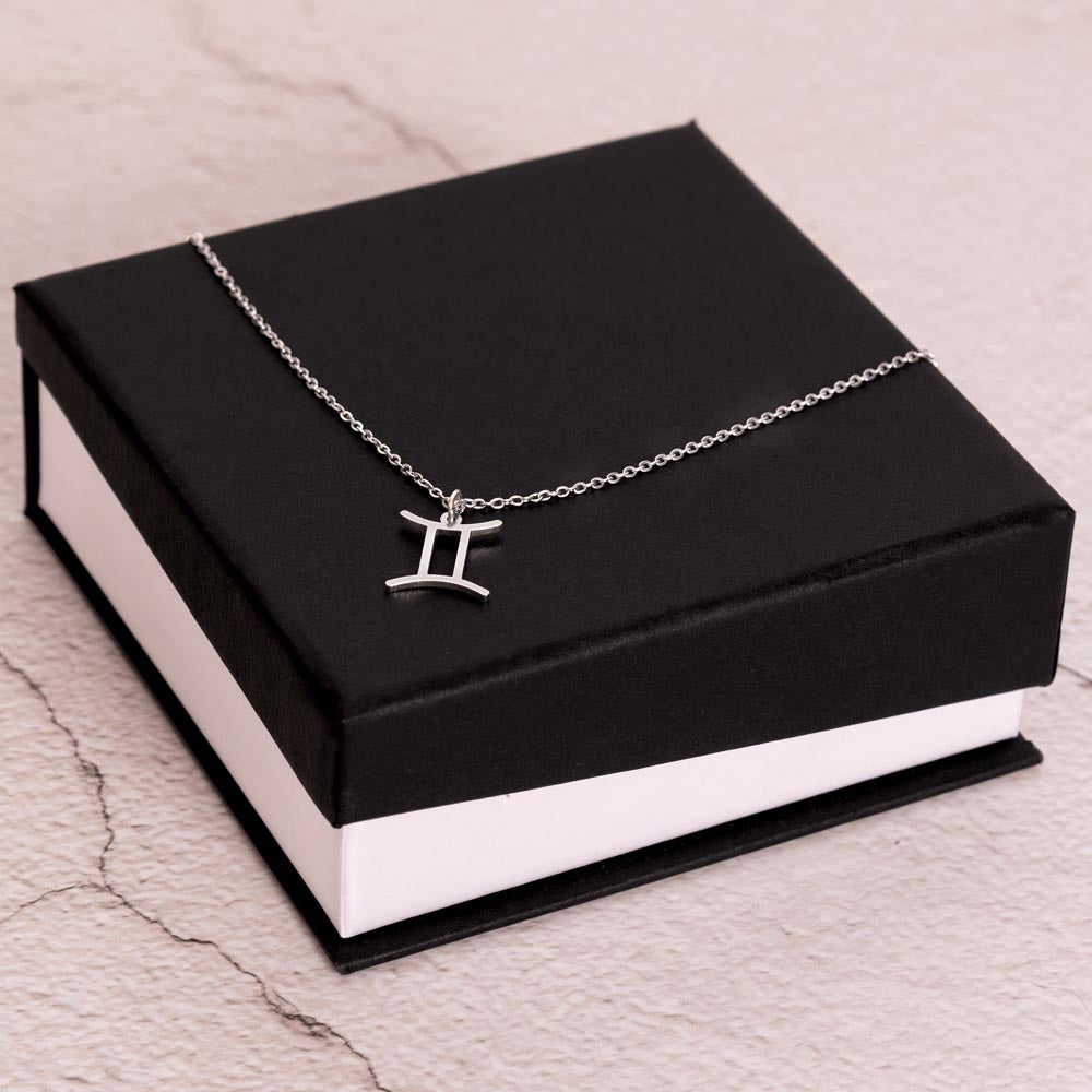 Stainless Steel Zodiac charm necklace laying on elegant black box.