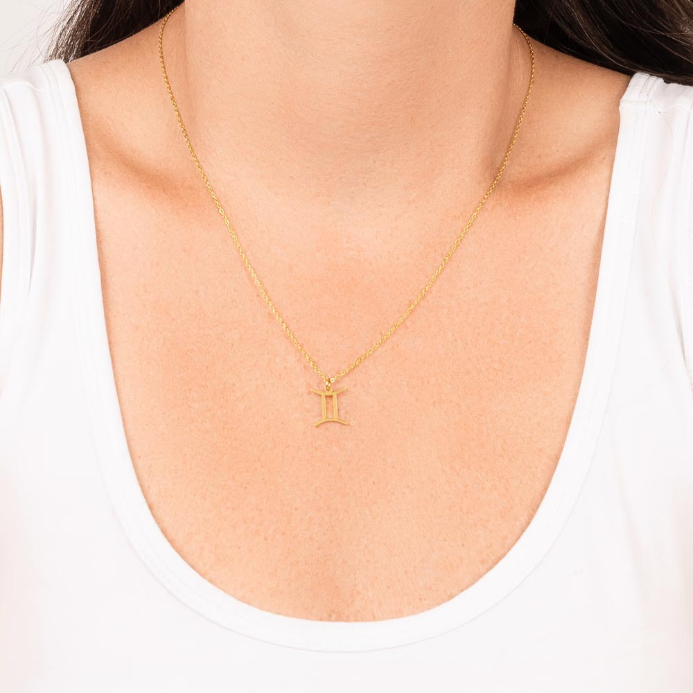 Woman wearing gold zodiac charm necklace.