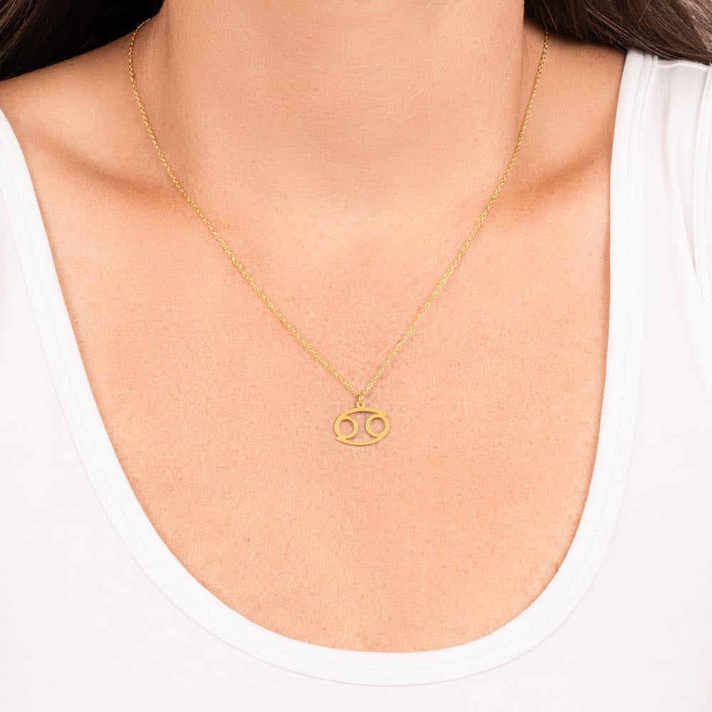 Woman wearing gold zodiac charm necklace.