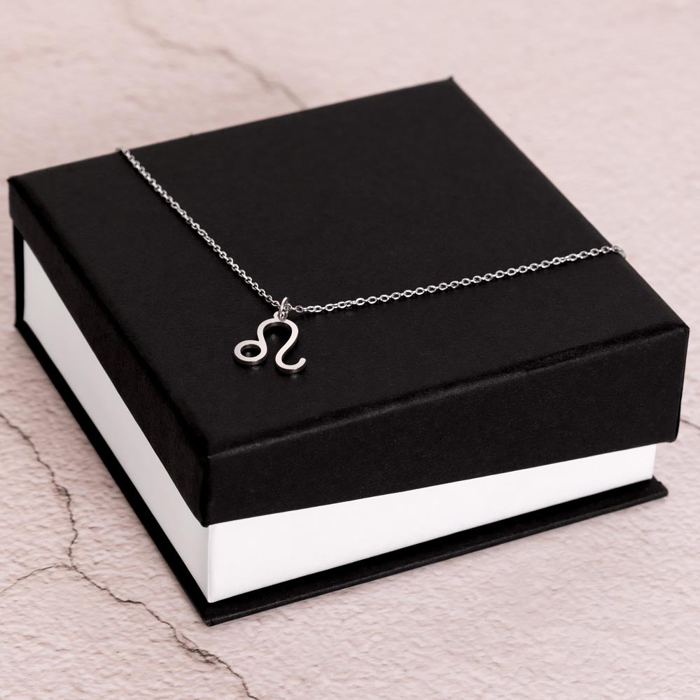 Stainless Steel Zodiac charm necklace laying on elegant black box.