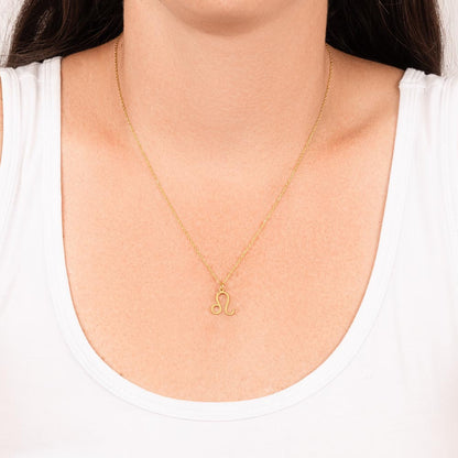 Woman wearing gold zodiac charm necklace.