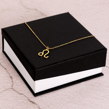 Gold Zodiac charm necklace on elegant black box.