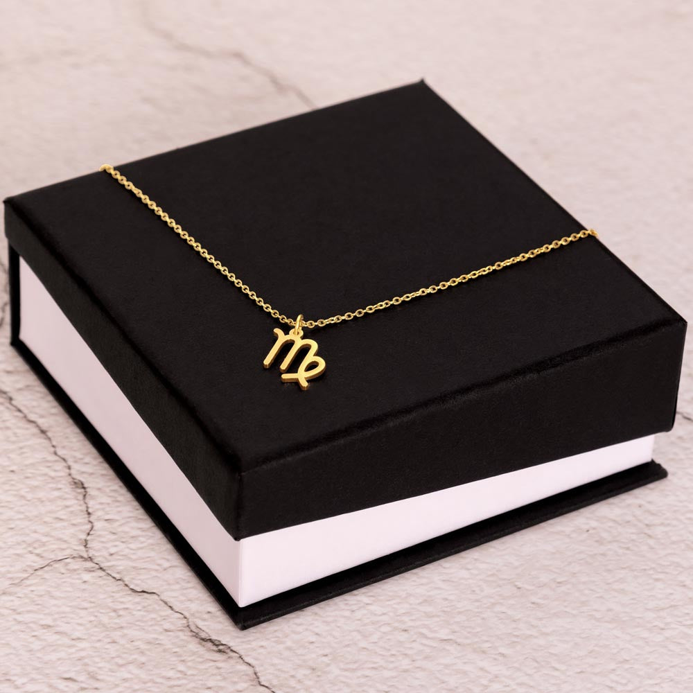 Gold Zodiac charm necklace on elegant black box.