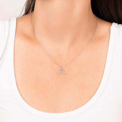 Woman wearing stainless steel zodiac charm necklace.