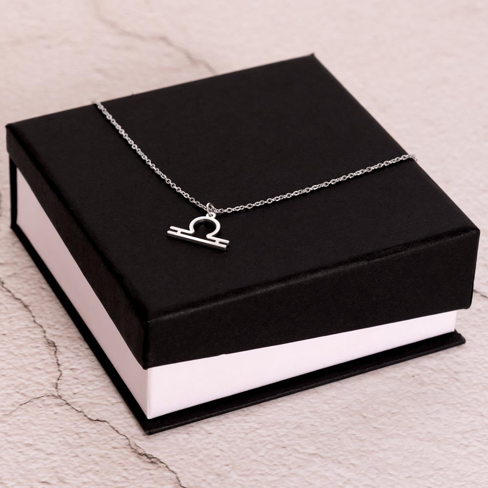 Stainless Steel Zodiac charm necklace laying on elegant black box.