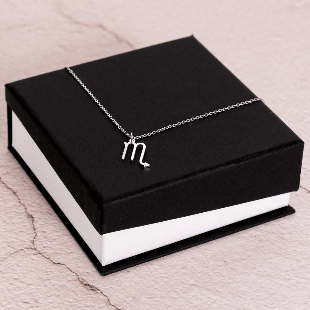 Stainless Steel Zodiac charm necklace laying on elegant black box.