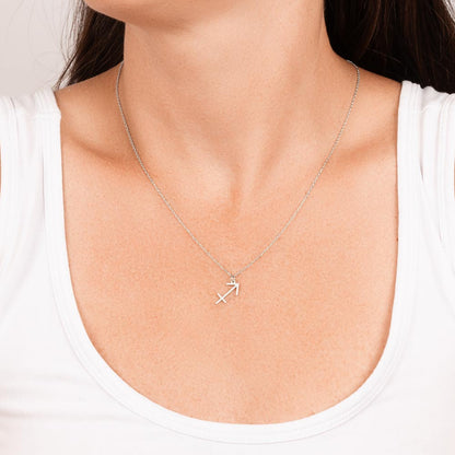 Stainless steel zodiac charm necklace hanging around woman’s neck.