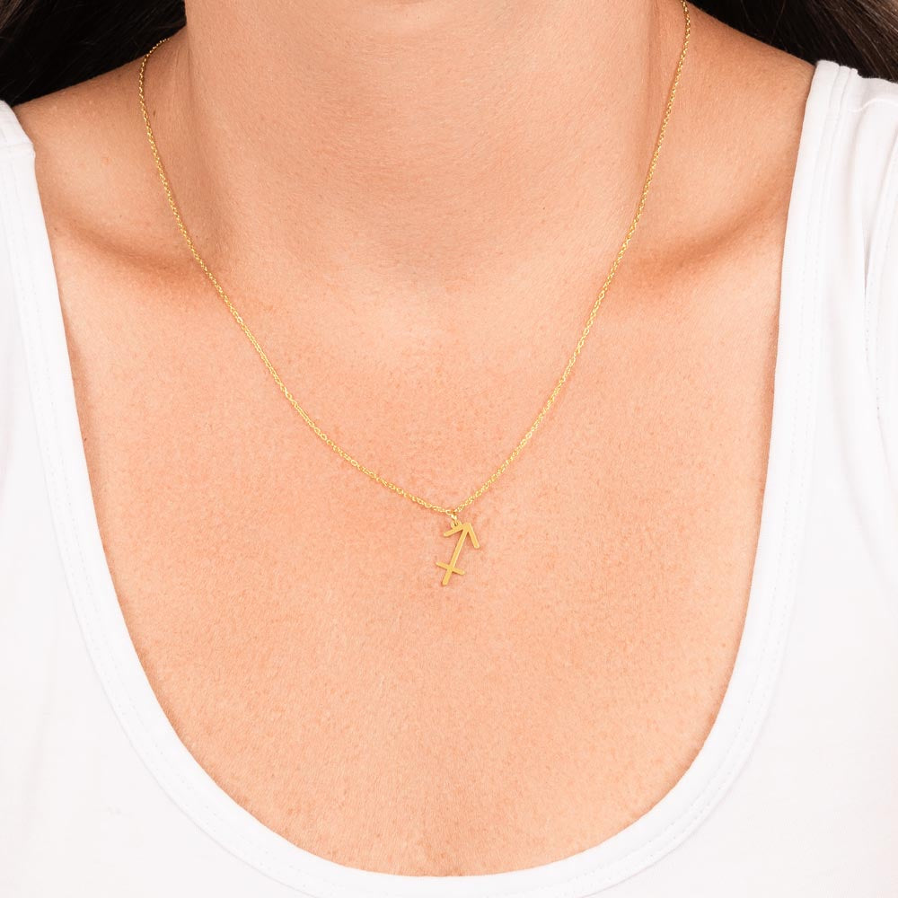 Woman wearing gold zodiac charm necklace.