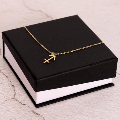 Gold Zodiac charm necklace on elegant black box.