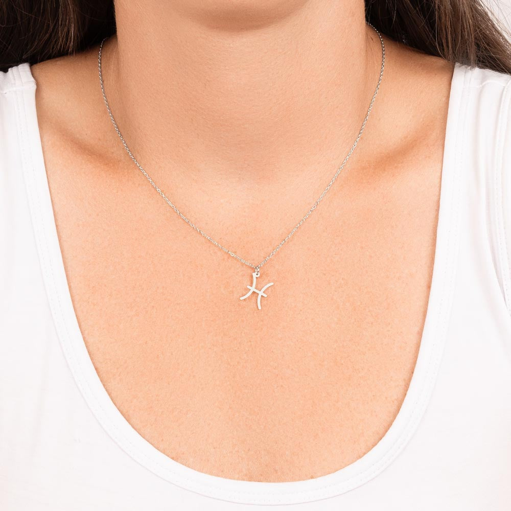 Stainless Steel Zodiac charm necklace hanging around woman’s neck.