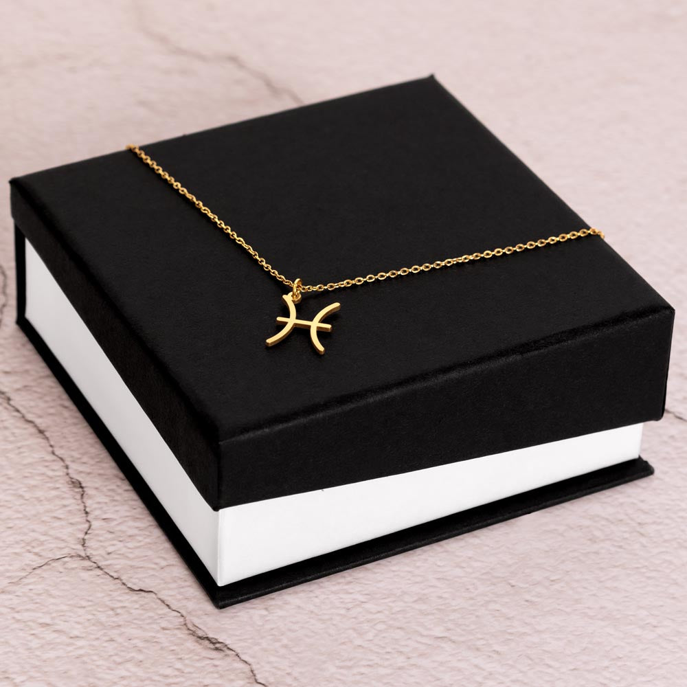 Gold Zodiac charm necklace in elegant black box, showcasing intricate astrological designs.