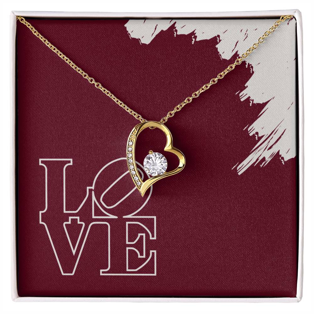 Polished white gold pendant surrounding a cubic zirconia crystal hanging in front of a message card reading LOVE