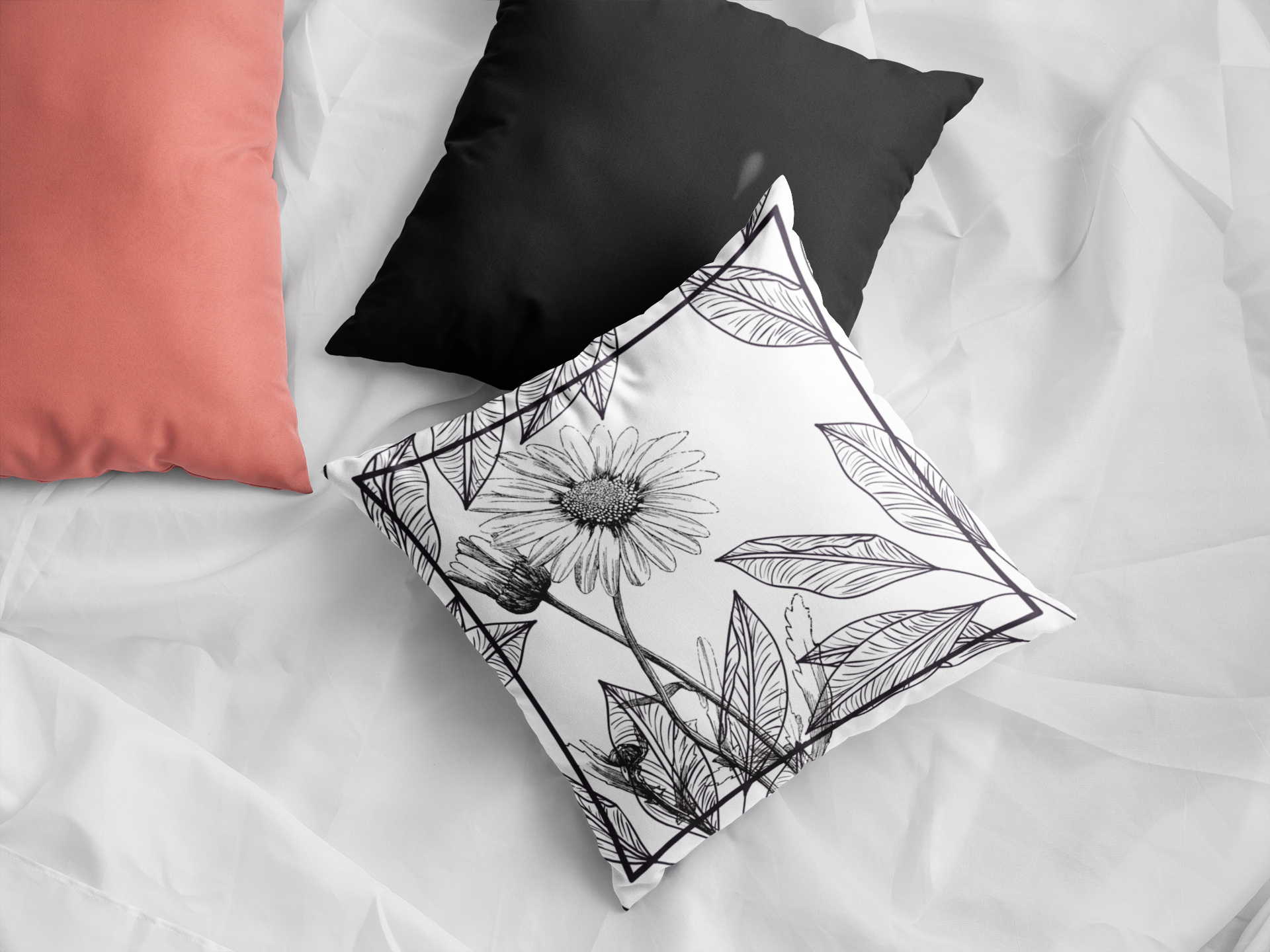 Mono Bliss pillow on bed showcasing from floral design with solid black backing.