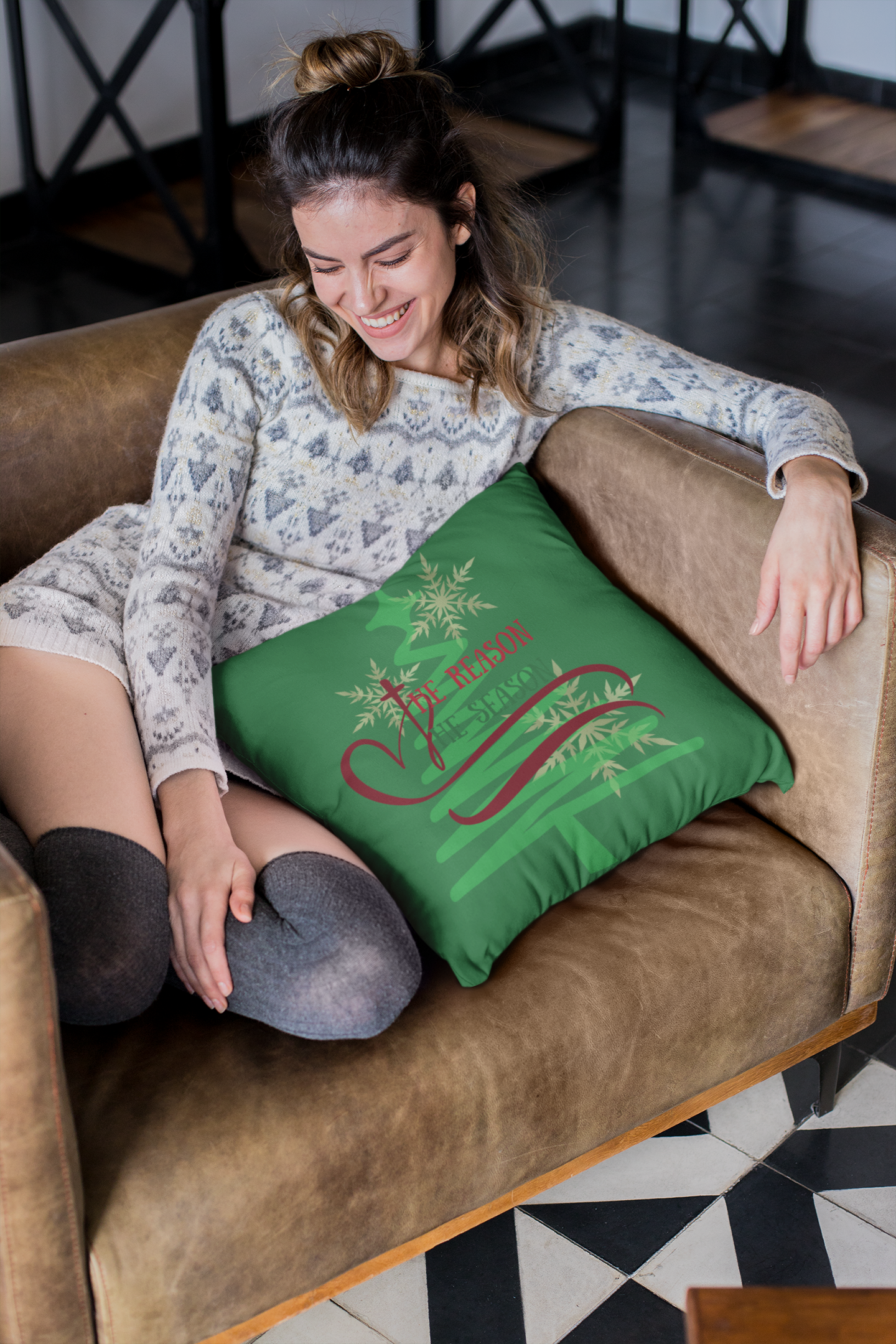 Girl sitting on couch with green “The Reason” throw pillow.