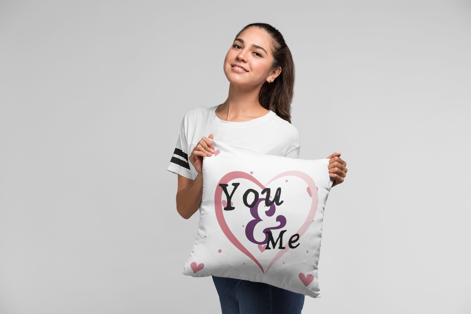 Girl holding “You & Me” Floating Hearts pillow.