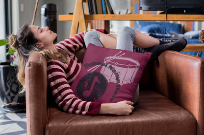 Woman sitting in chair with school band throw pillow.