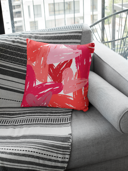 Red and pink heart throw pillow on black and white couch.